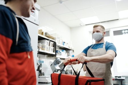 man-with-a-face-mask-holding-a-thermal-bag-4393669