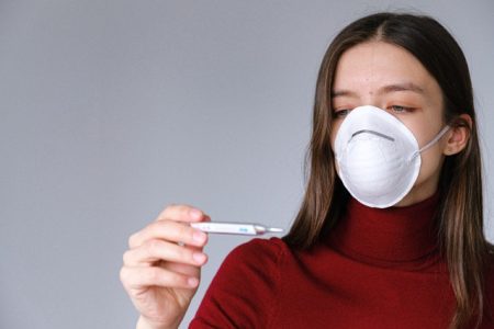 woman-in-face-mask-checking-thermometer-3987152