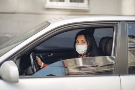 young-woman-wearing-medical-mask-driving-car-3983417